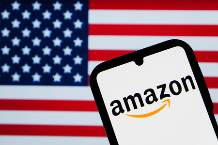In this photo illustration, an Amazon logo is displayed on a smartphone screen with the flag of America in the background.
