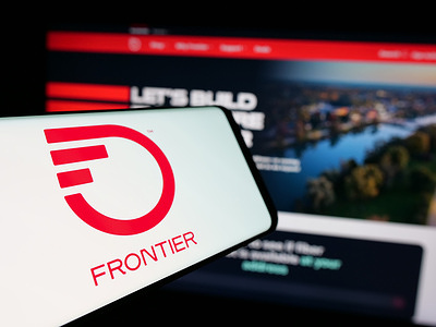 In this photo illustration, a mobile phone with the logo of American company Frontier Communications Parent Inc. is seen on screen in front of website.