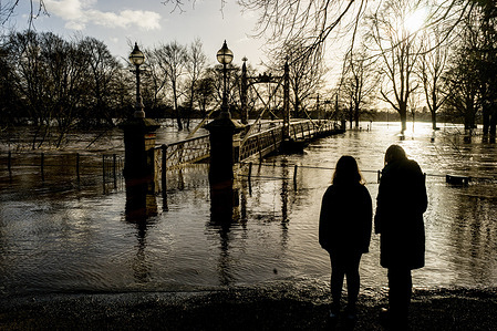 People watch the floodwater which has submerged the Victoria Bridge, as Storm Franklin brings flooding to the city of Hereford. River Wye reaches the top of flood defenses and floods surrounding areas.