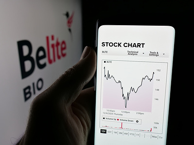 In this photo illustration, a person is holding a cellphone with the webpage of US biopharmaceutical company Belite Bio Inc. on screen in front of logo.