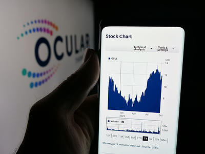 In this photo illustration, a person is holding a smartphone with the webpage of US biopharma company Ocular Therapeutix Inc. on screen in front of logo.