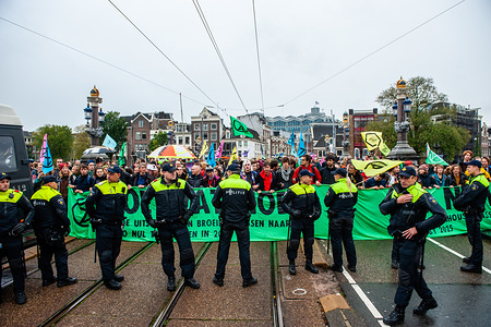 Policemen stand on guard in front of protesters holding a banner during the demonstration.
Hundreds of Extinction Rebellion activists blocked one of the important bridges in Amsterdam, the Blauwbrug in the center of the city so that the Dutch government can acknowledge the climate crisis.