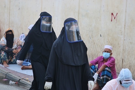 Women wearing face shields as a precaution, walking past people waiting in queue for the test.
Bangabandhu Sheikh Mujib Medical University is being used to conduct covid-19 tests as countries around the world are taking increased measures to stem the widespread of the SARS-CoV-2 coronavirus which causes the COVID-19 disease.