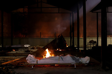 (EDITORS NOTE: Image depicts death)
A body lies amid burning pyres of victims who died due to the coronavirus (COVID-19) disease, at a cremation ground in New Delhi. 
In India the highest single-day spike in coronavirus infection. The report recorded 352,991 new Covid-19 cases and 2,812 deaths in the last 24 hours amid an oxygen crisis.