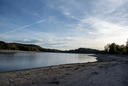 A view of the Lac de Vassivière (Lake Vassiviere). The bank of the lake shows how much the water lowered since the Spring. Lac de Vassivière is located in the Millevaches Regional Nature Park (Parc naturel régional de Millevaches en Limousin). Lac de Vassivière (Lake Vassiviere) is currently experiencing an unprecedented, historic drought. Due to a severe spring and summer hydric deficit, the artificial reservoir located on the border of the Creuse and Haute-Vienne departments has seen its water level drop dramatically.