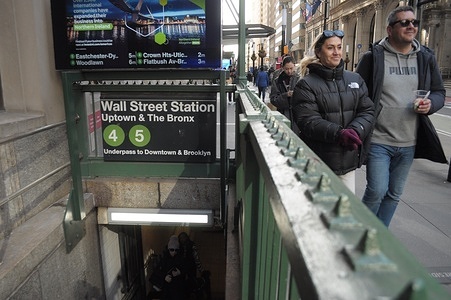People walk past the Wall Street subway station in the Financial District in Manhattan, New York City.