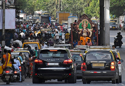 An idol of elephant headed Hindu god Ganesh is being carried to a place of worship through the traffic on the streets of Mumbai. Ganesh Chaturthi, celebrated as the birthday of elephant headed Hindu god Ganesh for 10 days starting from 31st August 2022. Devotees worship elephant headed Hindu god Ganesh as he is known as the god of knowledge, wisdom and prosperity.
