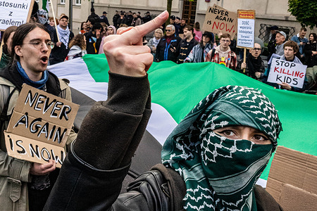 (EDITORS NOTE: Image contains profanity) A protester gestures towards the Israeli embassy during the demonstration. Pro-Palestinian activists marched through Warsaw to commemorate the 78th anniversary of the Nakba. Carrying flags and placards, protesters march from the Embassy of the United States of America to the Israeli embassy, making a stop at local bar Plan B, which was holding a pro-Palestinian arts fair. The Nakba, Arabic for “catastrophe”, refers to the mass displacement and dispossession of hundreds of thousands, and the murder of tens of thousands of Palestinians during the 1948 Arab–Israeli war and the establishment of the state of Israel. The Nakba is observed on the 15th of May each year, and the march takes place on the closest Saturday.