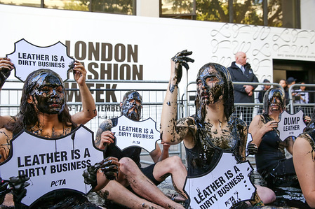 Activists with black "toxic slime" holding placards during the demonstration.
PETA (People for the Ethical Treatment of Animals) activist staged a protest with black "toxic slime" over their face and head to call attention to what they say is hazardous waste associated with the leather industry, during Fashion Week in London.
