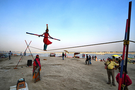 A little girl seen showing balance game on a Rope at the river bank of Varanasi for earning money and to support her family.