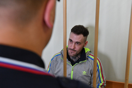 German citizen Patrick Schobel, suspected of drug smuggling, sits in the defendant's cage in a courtroom in St. Petersburg. Patrick Schobel was detained at Pulkovo Airport for carrying gummy candies containing cannabis.