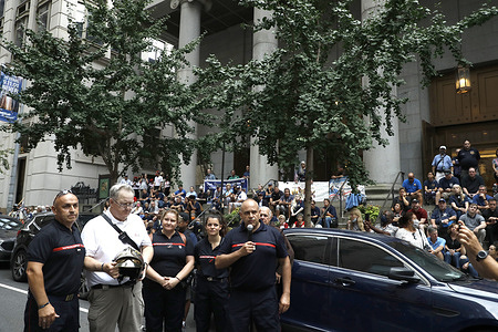 French firefighters present a helmet to a member of the NYFD during the 911 Walk of Remembrance from St. Francis of Assisi Church to St. Peters Church in downtown Manhattan. 
The march has been performed yearly to remember those lost during 911 terror attack and to remember Father Mychal Judge a chaplain who served the New York City Fire Department (NYFD). Father Judge was killed in the performance of his duty during 911.