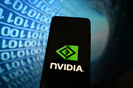 In this photo illustration, a Nvidia logo is seen displayed on a smartphone with binary code on the background.