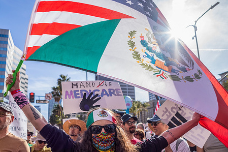 A protester holds a flag in a march and protest of President Trump's attacks on families, jobs, healthcare, and Social Security,'' in Los Angeles.