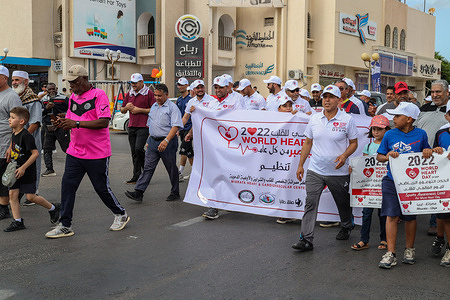 Students march through the Streets while holding placards and a banner during a rally to mark the World Heart Day in Misrata. People, including students, join the 12-kilometer march from the city center to the heart hospital to educate heart patients about the benefits of walking and exercise.