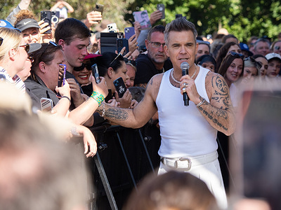 Williams spoke to an emotional fan named "Emily" who he offered a backstage pass to his next show to. Robbie Williams performs a public concert to thousands of fans at Melbourne's Federation Square, where Lord Mayor Nicolas Reece presented him with the honourable "keys to the city."