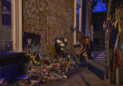 Residents of Charlottesville pay their respects at the site where Heather Heyer was killed last year when James Alex Fields drove his car into a crowd of people following the Unite the Right Rally in Charlottesville, Virginia. This weekend marks the one year anniversary of the Unite the Right rally in Charlottesville and subsequent riot which claimed the lives of three people, Heather Heyer who was killed by White Nationalist James Alex Fields, and two police officers whose helicopter crashed while patrolling the events. The city held vigils and memorial events in honor of those affected by last years violence.