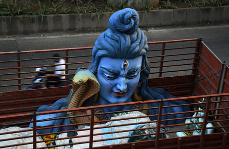 View of a sculpture of Hindu god Shiva inside a truck parked on the streets of Mumbai. Sculptures of Hindu god and goddesses are rented by devotees during the festive season as a part of decoration at the pandals (temporary shelters) to make it look visually pleasing and attract more devotees footfall during the festival celebration.