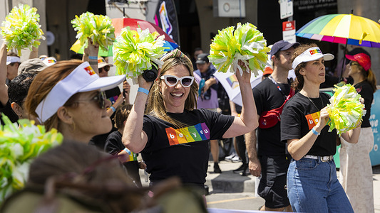 A march attendee seen holding green colored pom-poms. Midsumma is a month-long pride festival which occurs annually. Held each summer, the festival spans weeks of performance, visual art, community events and public celebration across the city culminating in the march through St Kilda.
