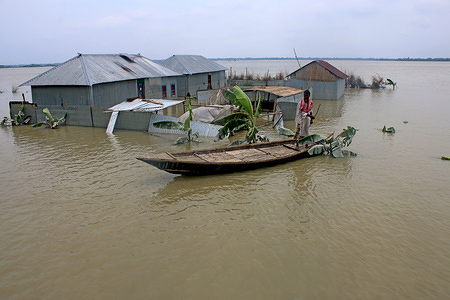 A Bangladeshi man pulls a small boat in front of his house through flood waters following heavy mosoon rains in Tangail.
Over million people have been affected by floods triggered by the monsoon rains and overflowing river in north, north-eastern and hilly regions in Bangladesh.