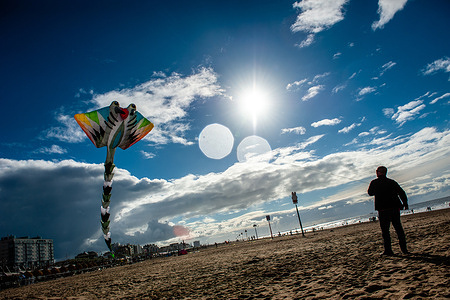 A man is seen flying his huge kite in the sky. The International Kite Festival Scheveningen makes the most of the consistent prevailing winds blowing along The Hague's beach resort. Kite builders and enthusiasts from around the world come together to fly the fruits of their creative labor. Almost at the end of the event, The Holland Kite Team flew their large kite, which officially received the Guinness World Record during the Bristol International Kite Festival, in 1997. The annual event sees the skies over the southern part of Scheveningen beach filled with giant kites of every shape and colour.