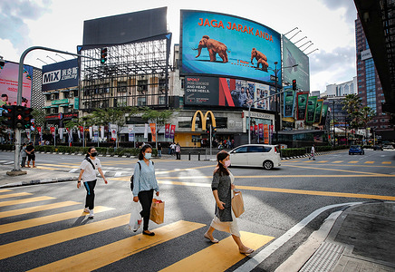 Pedestrians wearing facemasks as a precaution against the spread of the coronavirus seen crossing the junction during the second day of the Hari Raya celebrations.
Malaysia's Prime Minister Muhyiddin Yassin, has announced the whole of Malaysia is placed under the Movement Control Order (MCO) from May 12 to June 7, 2021, due to the rising of Covid-19 infections.