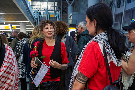 Nina Ptak talks to a friend upon her return. Pro-Palestinian supporters gathered at Chopin Airport to welcome the four Polish participants of the Global Sumud Flotilla recently deported from Israel. Ewa Jasiewicz, Nina Ptak, Polish MP Franek Sterczewski, and Palestinian Omar Faris were detained by Israeli forces in international waters and later transferred to Athens, Greece, before returning home. The flotilla, one of the largest with over 40 vessels, aimed to deliver aid to Gaza and challenge Israel’s naval blockade, which many international observers consider a violation of international law.