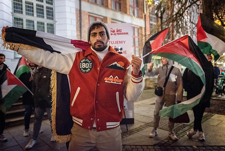 A protester with flags takes part during the demonstration. On 4 November 2023, a protest was held in Gdansk to show solidarity with the Palestinians and collectively express opposition to the war crimes affecting the community. Demonstrators demanded a halt to war crimes. They protested against imperialism, the persistent occupation, and the continuous violation of human rights in the Palestinian territories.