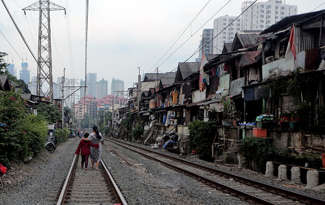 JAKARTA, INDONESIA - MAY 08, 2020: People walk along an empty Petamburan railroad during the Coronavirus (COVID-19) lockdown crisis.
Poor conditions of living on the banks of the Petamburan railroad. A number of semi-permanent houses on the edge of the railroad make the area look dirty.