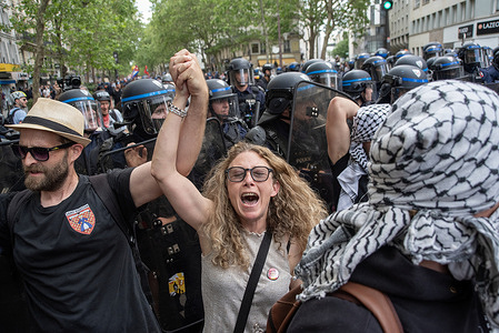 Protesters walks hand in hand and chant slogans during the May Day demonstration in Paris. Tens of thousands of trade unionists and grassroots movement members gathered to celebrate the achievements of the labour movement and raising awareness of the fight for workers' rights in Paris, France.