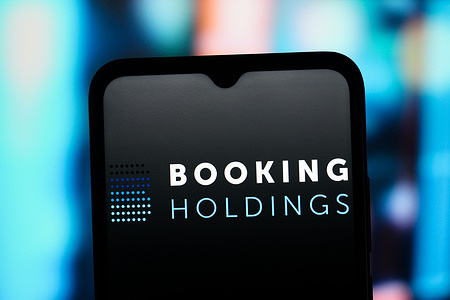 In this photo illustration, the Booking Holdings logo is seen displayed on a smartphone screen.