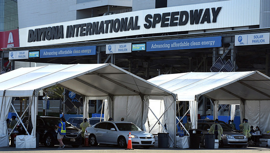 Healthcare workers from AdventHealth hold a drive-thru COVID-19 testing at Daytona International Speedway, with results from the saliva test available in 2-3 days.