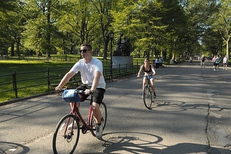 People ride bicycles in Central Park during a summer heat wave in Manhattan, New York City. New Yorkers are experiencing high temperatures above 90 degrees Fahrenheit and humid weather. Weather advisories are urging people to stay cool and hydrated.