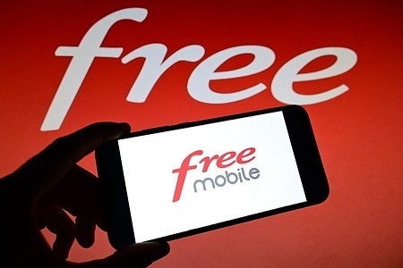 In this photo illustration the French telecommunications company Free logo is seen displayed on a smart phone and in the background.