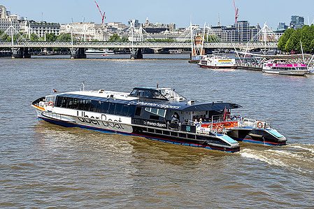 Uber boats seen on the River Thames packed with passengers as they enjoy the warm weather.