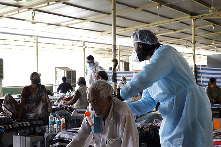 A healthcare worker wearing a personal protective equipment suit (PPE) attends to a Covid-19 patient inside a Covid-19 Care center set up by a Charitable institute in the wake of rising cases of the Covid-19 in New Delhi.