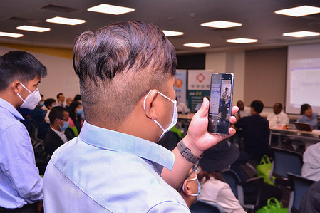 A Chinese investor in Kenya recording proceedings on his smartphone during a workshop to familiarize the investors with Kenyan Law held in Nairobi.