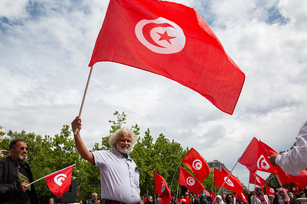 Protesters hold Tunisian flags as they take part in a demonstration against Tunisian president Kaïs Saïed in the center of the French capital Paris. In Paris, around fifty participants protested against the Tunisian president Kaïs Saïed because he suspended the constitution. They consider the president too authoritarian and are calling for a truly democratic political system.
