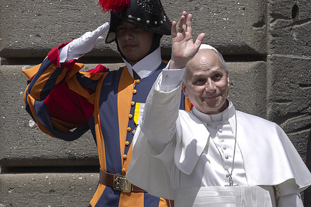 Pope Leo XIV greets a child at the end of the Angelus prayer from his summer residence in Piazza della Libertà in Castel Gandolfo, near Rome.