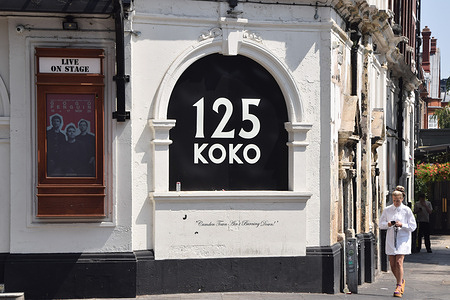 A woman walks past a 125 KOKO sign at KOKO concert venue and former theatre in Camden Town as the iconic live music venue celebrates its 125th anniversary.