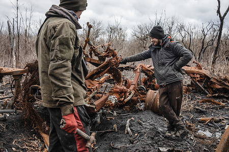 Local men dismantle the remains of destroyed and burned Russian military equipment for scrap metal, Kharkiv region, Ukraine. Driving along the roads of the Kharkiv region close to Donbas, there are large volumes of broken and burnt-out military equipment on the roadside, in fields and forests. Men can often be seen looking for recyclable scrap metal, for which they receive 2 hryvnias ($0.05USD) per kilogram. Typically they cannot collect more than 500 kilograms per day.