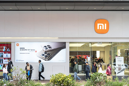 Pedestrians walk past the Chinese multinational technology and electronics brand Xiaomi flagship store in Hong Kong.