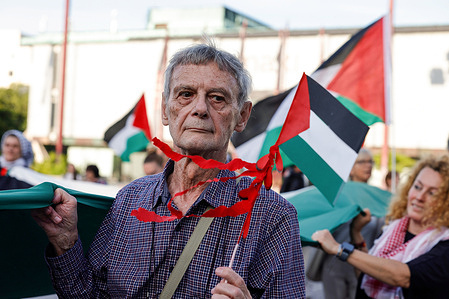 A protester carries a Palestinian flag during a protest. A protest in support of Palestine was held in Ljubljana after the newly formed government and its right-wing prime minister, Janez Jansa, removed the Palestinian flag that hung on the main government building. The move came with a sharp turn in Slovenian foreign policy, closer ties with Israel, and the alleged interference in the parliamentary elections by the Israeli company Black Cube.