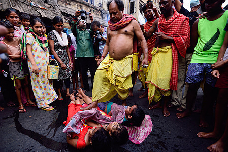 A gajan sanyasi steps on a child as part of a Hindu ritual on the last day of the Bengali New Year. The Gajon festival or "Shiber Gajon" in West Bengal is celebrated on the last two days of the month of Chaitra. The central theme of this festival is deriving satisfaction through non-sexual pain, devotion, and sacrifice. Devotees collect remains of dead body parts, mainly head parts, from different burial grounds. Before the day of Gajon, they carry human skulls in a procession to appease Hindu Lord Shiva. This ritual has been controversial for a long time.
