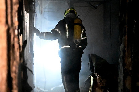 Firefighters work at the scene of a residential building fire in Kyiv, following an attack by Russian troops. Russian strikes on Ukraine's capital and its suburbs killed at least three people, Kyiv's mayor said Friday, as the air force issued a countrywide missile warning. The attack on Kyiv ignited fires and damaged apartment buildings, with "three dead and 13 wounded," according to Mayor Vitali Klitschko.