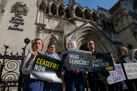 Activists hold up placards at a demonstration outside the Royal Courts of Justice. Human rights activists supporting Amnesty International, Oxfam and Human Rights Watch hold a demonstration outside the Royal Courts of Justice in Central London. The protest is held as lawyers representing the pressure groups prepare to take legal action against the UK governments continued arms sales to Israel.