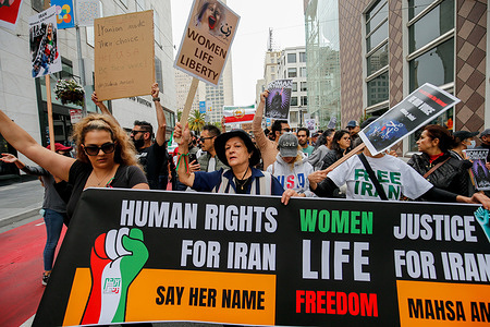 People march on the street of San Francisco with placards expressing their opinion during the demonstration. After the death of Iranian girl Mahsa Amini, protests and rallies to support Iranian have happened across the entire world. In San Francisco, thousands of people rally and march on the street with photos of Mahsa Amini, banners, placards and the flag of Iran. People who join the rally think everyone should support the Iranian and they yell "Woman,Life, Freedom" during the rally.