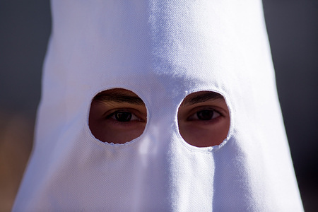A Nazarene from the Brotherhood of Jesus of Love poses during the procession of the image of Our Father Jesus of Love (La Borriquita). This procession inaugurates Holy Week in Madrid.