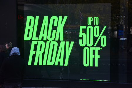 People walk past a Black Friday sale promotion at a store in Oxford Street.