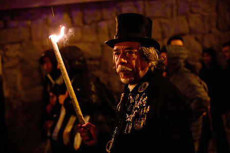 A member of the Sardine Brotherhood holds a torch during the burial of the Sardine, a carnival procession that wound through the streets. The Burial of the Sardine is a funeral-style procession held every Ash Wednesday to mark the end of Carnival. The tradition dates back to the 18th century and signals the start of the 40 days leading to Holy Week.